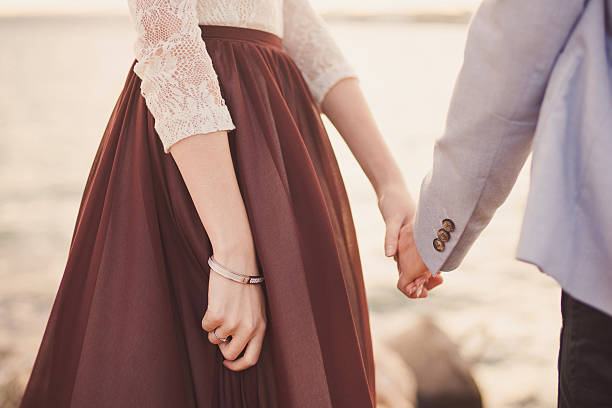 Couple holding hands at sunrise