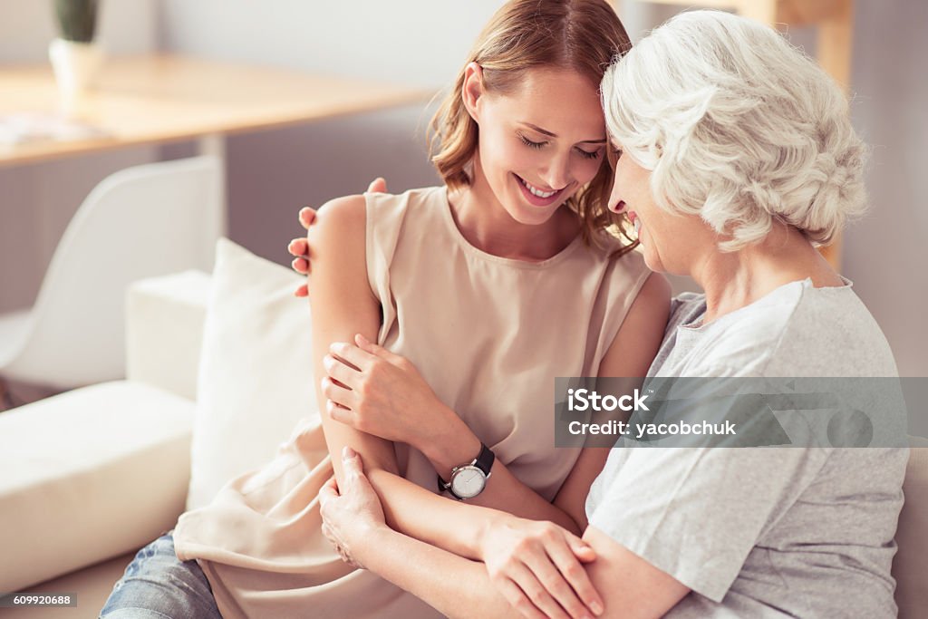 Mãe sênior positiva e sua filha abraçando - Foto de stock de Mãe royalty-free