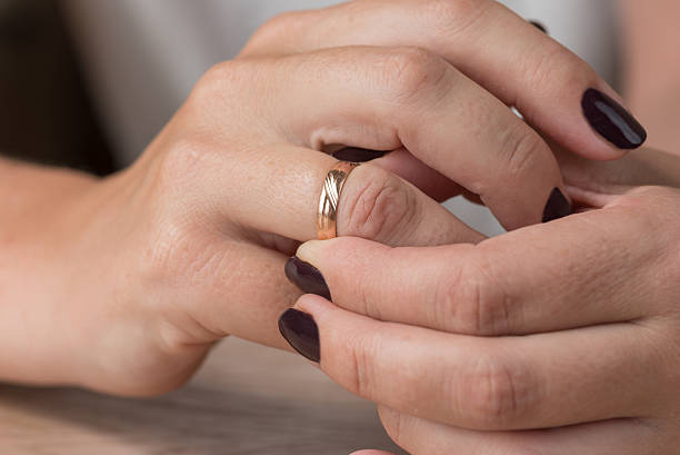 istock Divorce, separation: woman removing wedding or engagement ring 609921928