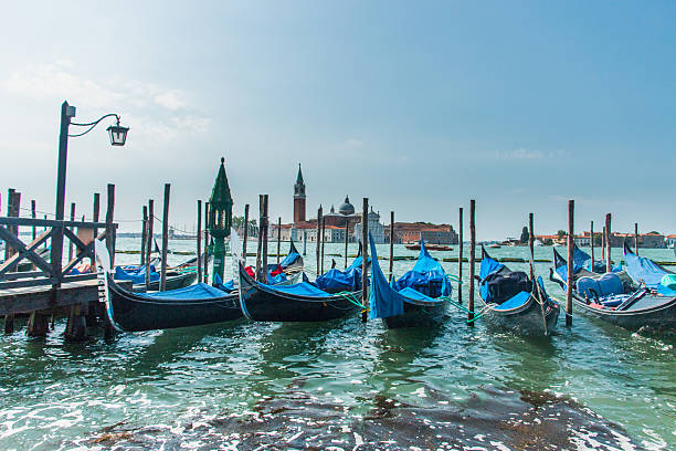 istock Several gondolas hitched to the wharf in Venice 609922972