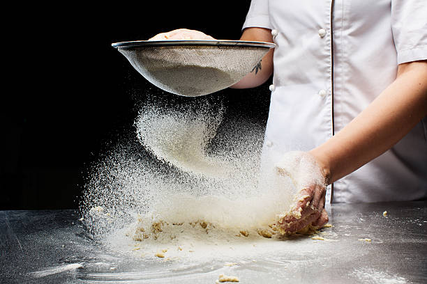 Le mani delle donne impastare l'impasto. - foto stock