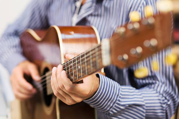 istock Handsome man playing guitar at home 609923662