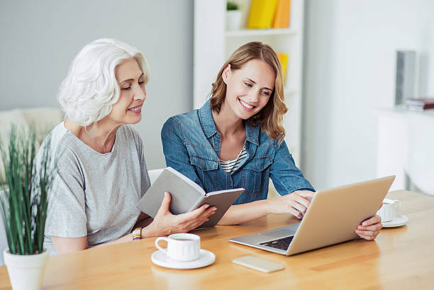 istock Cheerful senior woman and her daughter using laptop 609924102