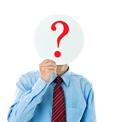 Confused businessman holding question mark against white background.