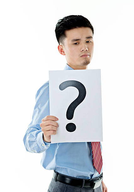 istock Confused businessman holding question mark 609934612