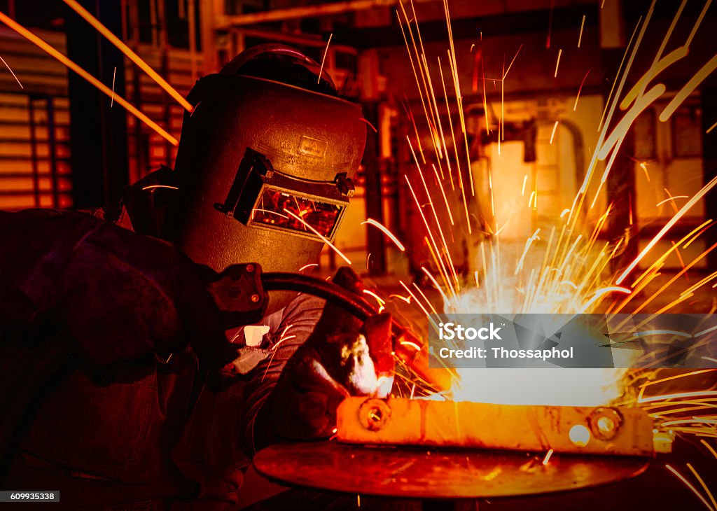 worker welding in factory worker welding in  automotive factory Welder Stock Photo