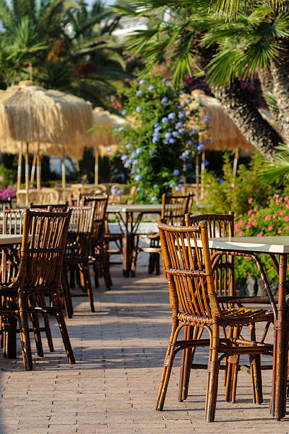 istock Tables and wicker chairs with straw sunshades in the restaurant 609936350