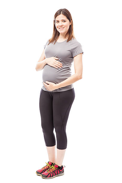 cute pregnant woman in sporty outfit - pregnant isolated on white stockfoto's en -beelden