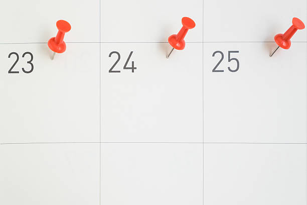 spille rosse appuntate nelle date del mese su carta del calendario - 1 2 months foto e immagini stock