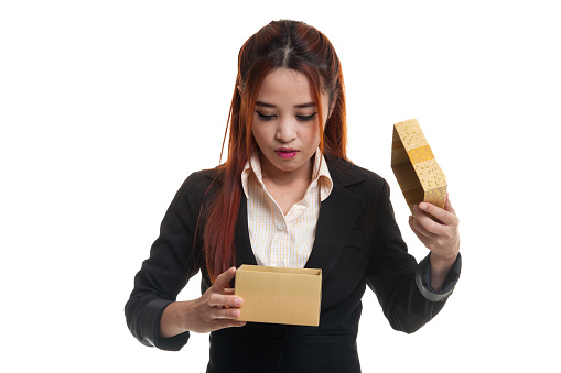 Formally dressed woman holding a stack of ironed and packed clothes wrapped with red ribbon as a gift isolated on white background