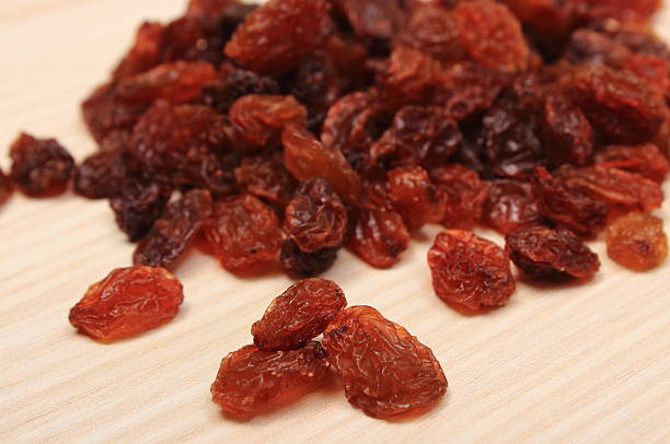 istock Brown raisins on wooden table, healthy eating 609940074
