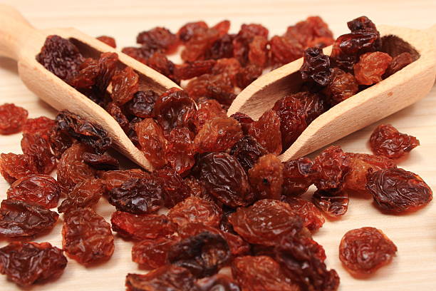 istock Brown raisins with spoon on wooden table, healthy eating 609940108
