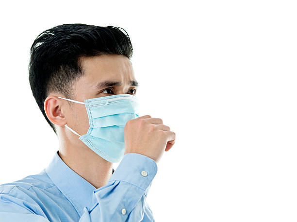Image of a doctor or nurse wearing an N95 surgical mask, scrubs and disposable surgical hat