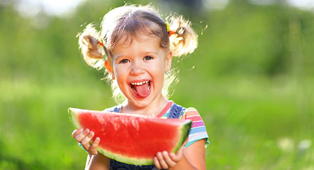 istock Happy child girl eats watermelon 609942912
