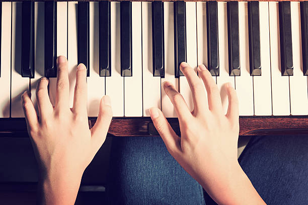 istock Female hands playing piano with vintage look 609943330