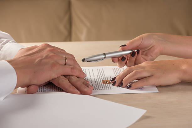 istock Wife and husband signing divorce documents, woman returning wedding ring 609945316