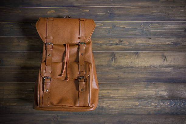 istock Brown leather bag on wooden table 609948722