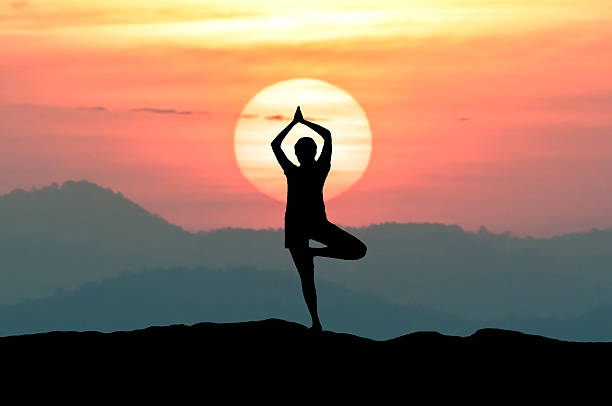 istock Silhouette young woman practicing yoga on the mountain 609953046