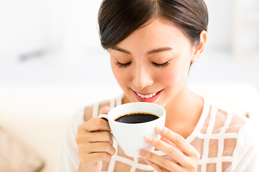 young smiling woman drinking coffee in the morning
