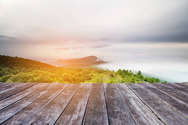 istock wooden floor and Blured Mountain forest landscape and cloudy 609953778