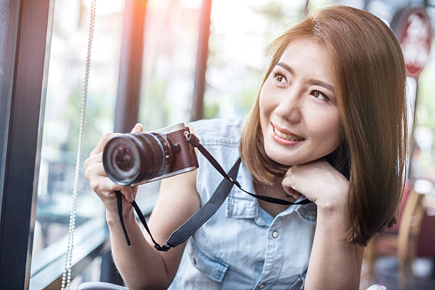 istock smiling girl with camera in coffee shop 609955264
