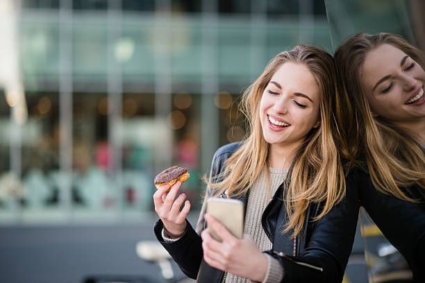 istock Teenager with donut and mobile 609956764
