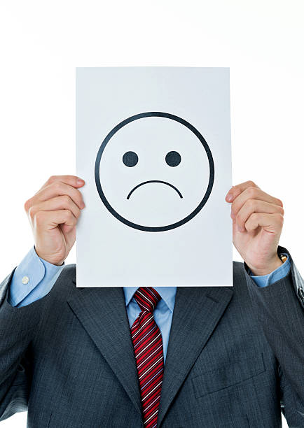 istock Businessman holding paper with sad face 610006616