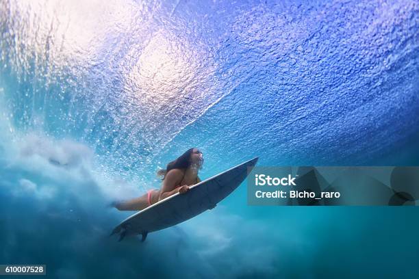 Beautiful Surfer Girl Diving Under Water With Surf Board Stock Photo - Download Image Now