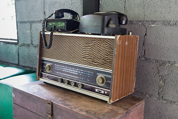istock Vintage radio receiver device on old wooden box 610011396