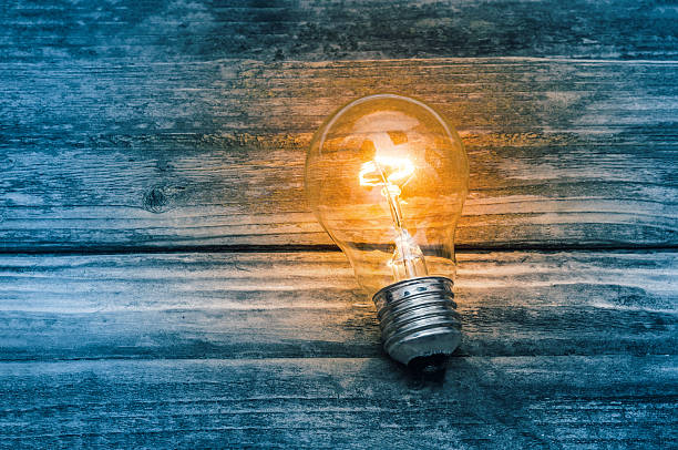 istock Light bulb on blue wooden background 610015120