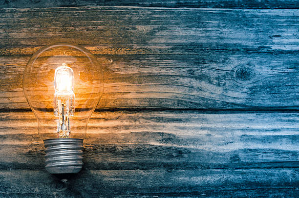 istock Light bulb on blue wooden background 610015278