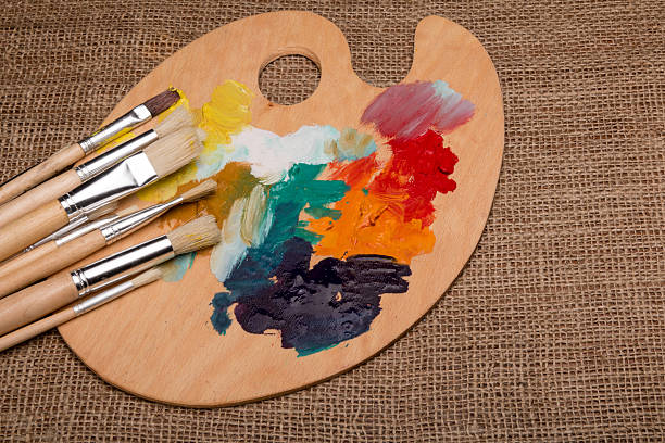 istock Wooden palette with paints and brushes 610016210