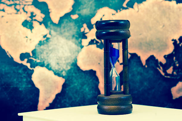 istock Hourglass against grunge world map 610016420