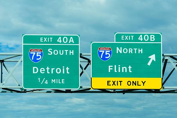 Detroit and Flint Michigan Exit Signs Freeway signs indicate the way to Detroit and Flint, Michigan. flint michigan stock pictures, royalty-free photos & images