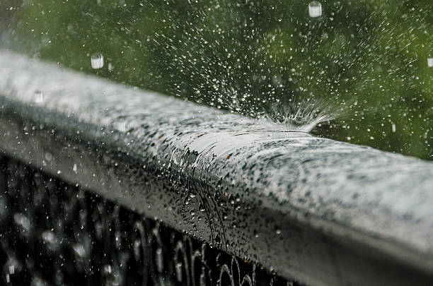 Rain drops bouncing off metal railing Drops bouncing off metal railing during heavy rain bounce off stock pictures, royalty-free photos & images