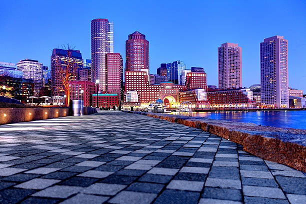 Downtown Boston Skyline along the Harborwalk Downtown Boston Skyline along the Boston Harbor waterfront. The Boston cityscape is a mixture of old and new buildings. Boston is the capital and largest city in Masssachusetts. Boston is the largest city in New England  harborwalk stock pictures, royalty-free photos & images