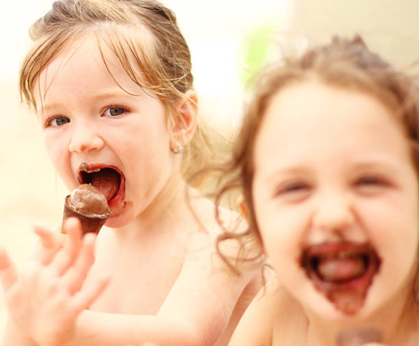 istock Girls eating ice cream on beach 610036284