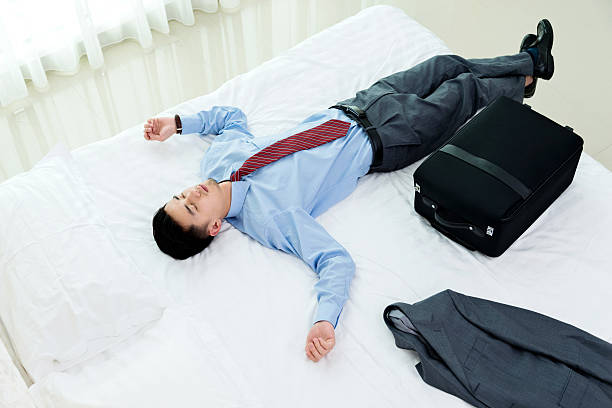 istock Businessman lying on bed with luggage 610037068