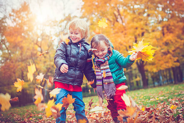 little boy and girl in autumn park - smiling little girls little boys autumn imagens e fotografias de stock