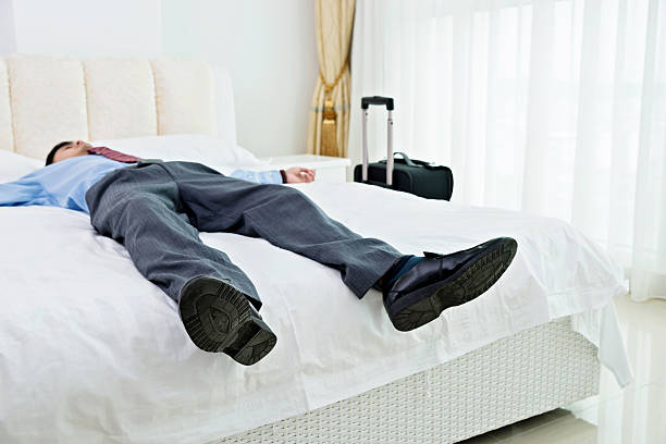 istock Businessman lying on bed with luggage 610037672