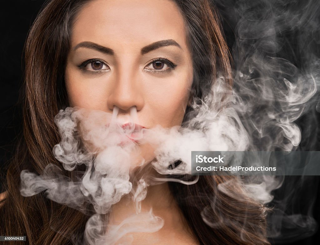 Belle femme soufflant de la fumée de vape - Photo de Cigarette électronique libre de droits