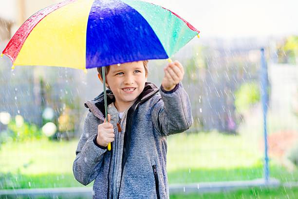 istock Seven years old boy standing at the rain 610041252