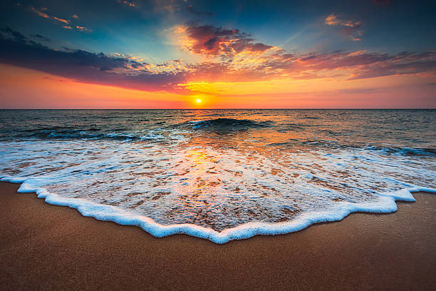 wunderschönen sonnenaufgang über dem meer  - landschaft stock-fotos und bilder