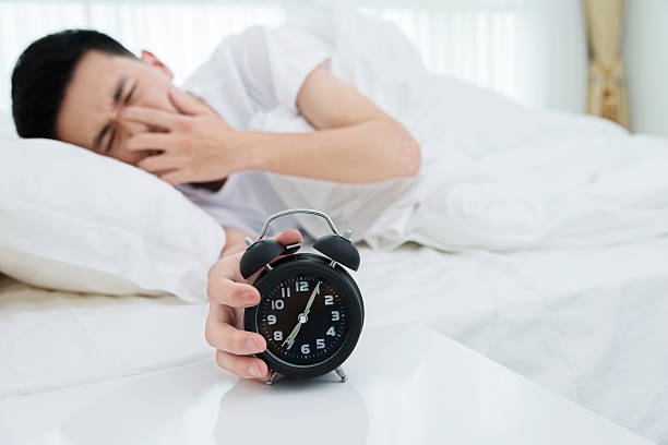 istock Man reaching to turning off alarm clock 610042432