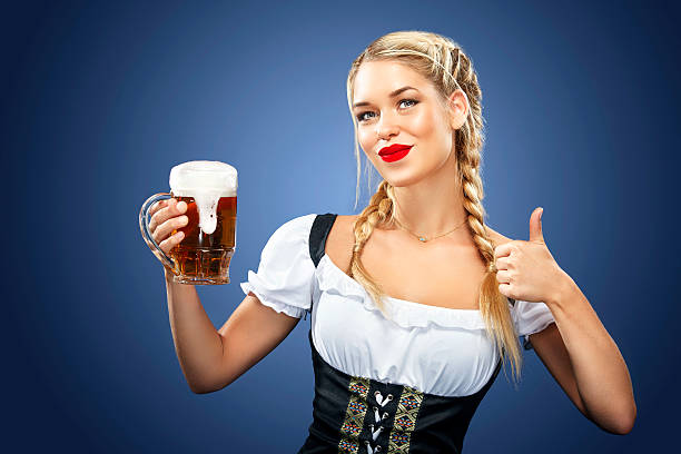 Young sexy Beer Fest waitress, wearing a traditional Bavarian dress, serving stock photo