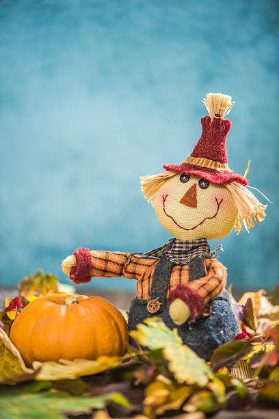 istock Funny scarecrow harvesting pumpkins 610043040
