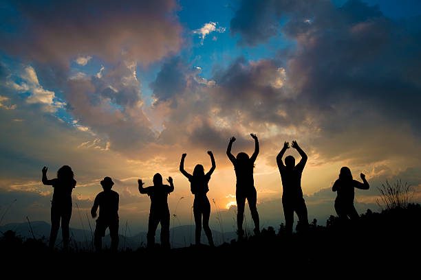 istock silhouette of young people jumping 610043628