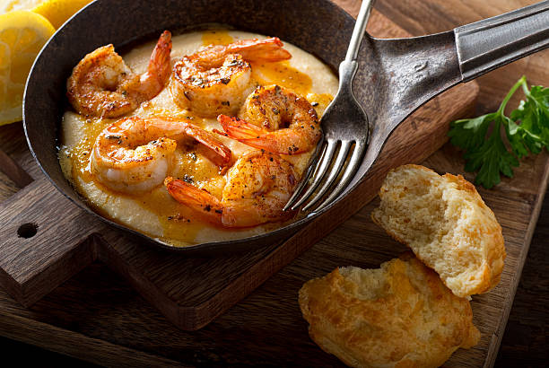 Cajun Style Shrimp and Grits A pan of delicious fresh homemade cajun style shrimp and grits with cheddar biscuit. cajun food photos stock pictures, royalty-free photos & images