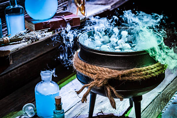 istock Full of magic mixture witch pot with blue smoke 610044354