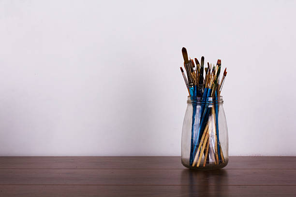 istock Paint brushes in a pot against a white background 610045498